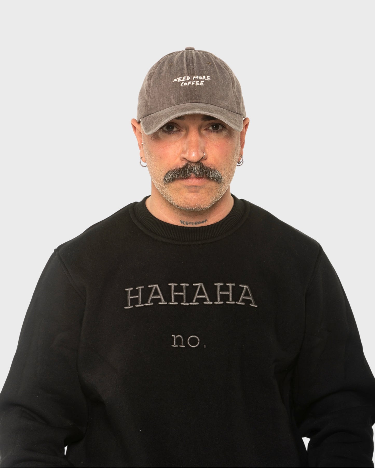 A man wearing the Need More Coffee Dusty Brown Washed Cap