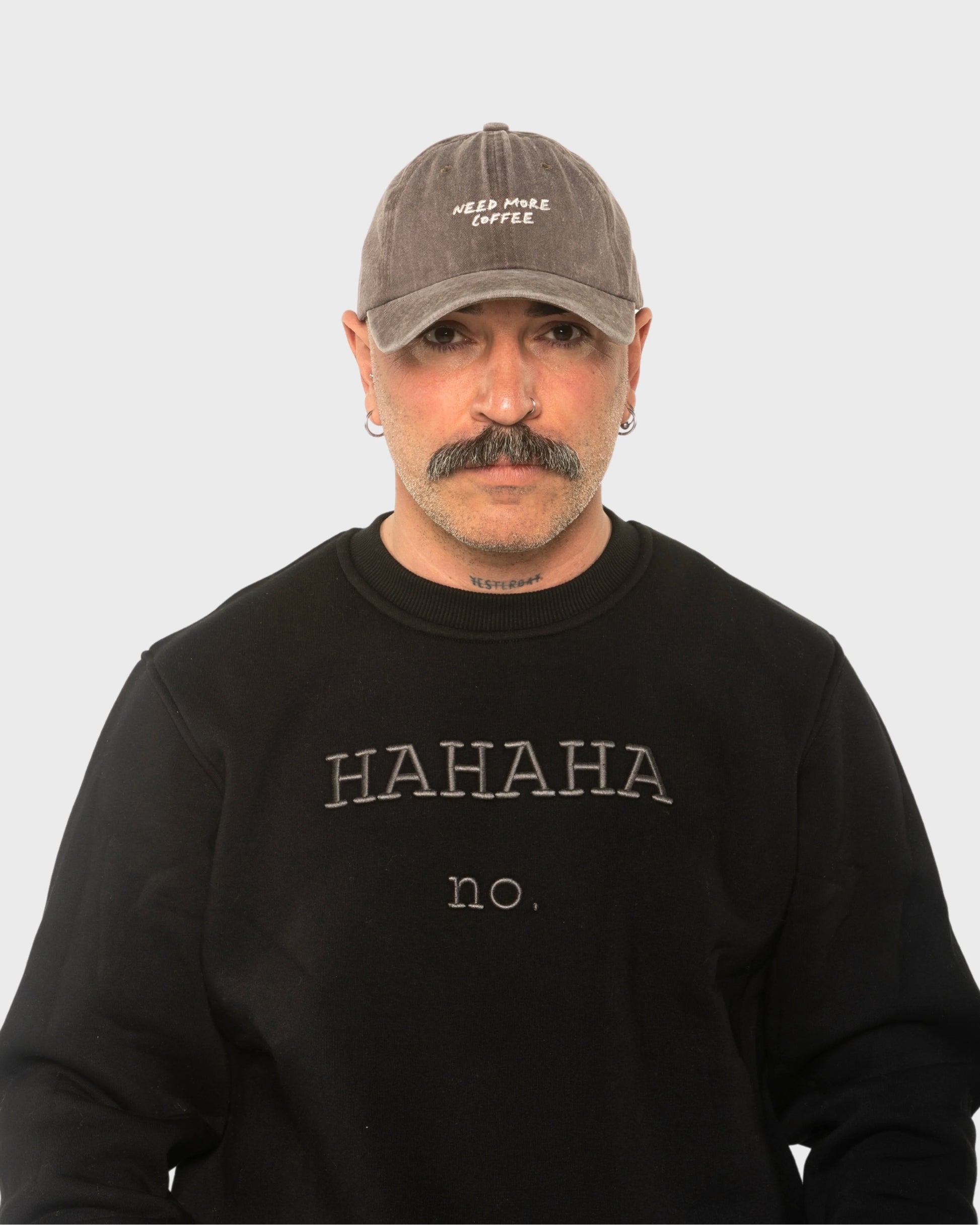 A man wearing the Need More Coffee Dusty Brown Washed Cap