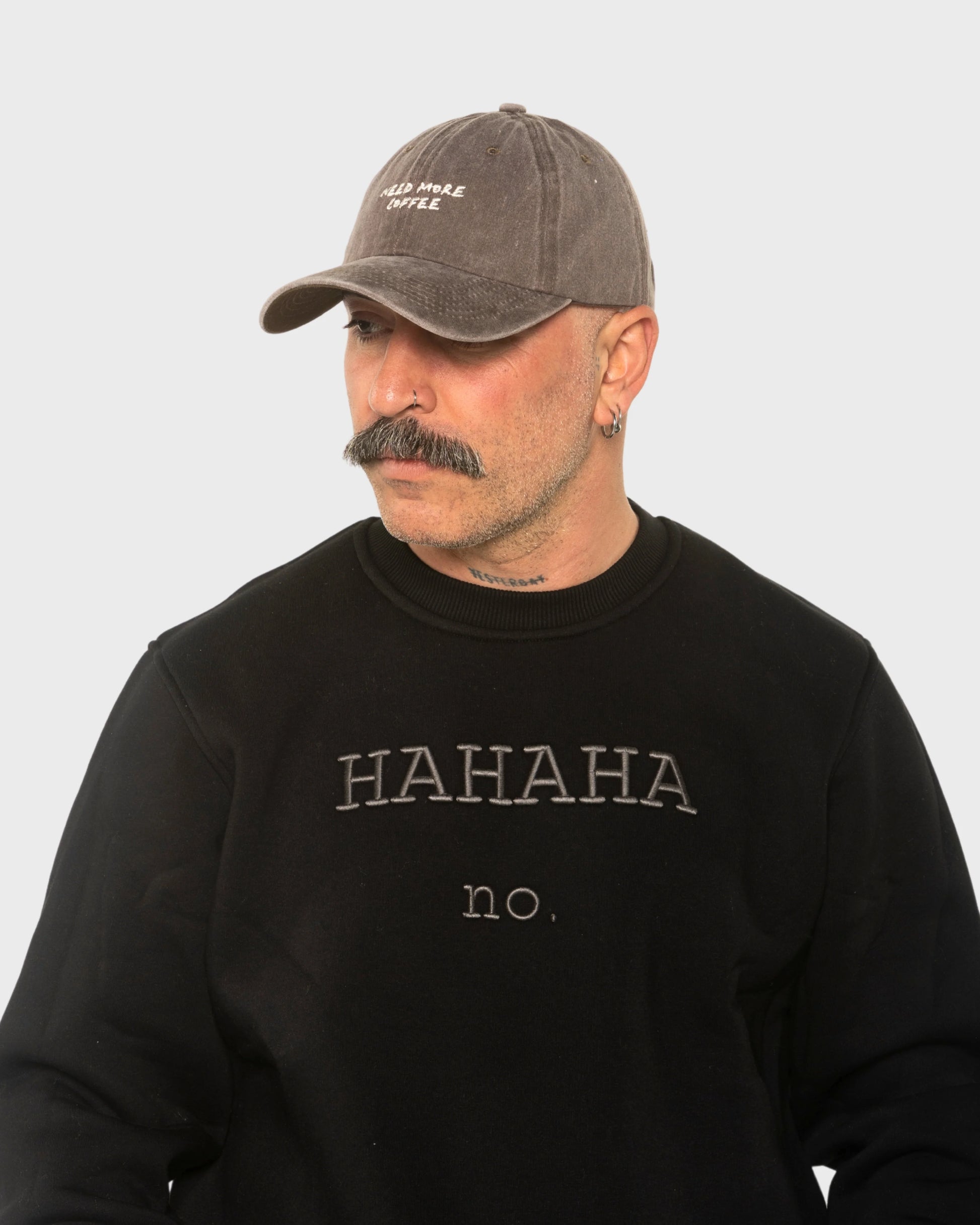 A man wearing the Need More Coffee Dusty Brown Washed Cap