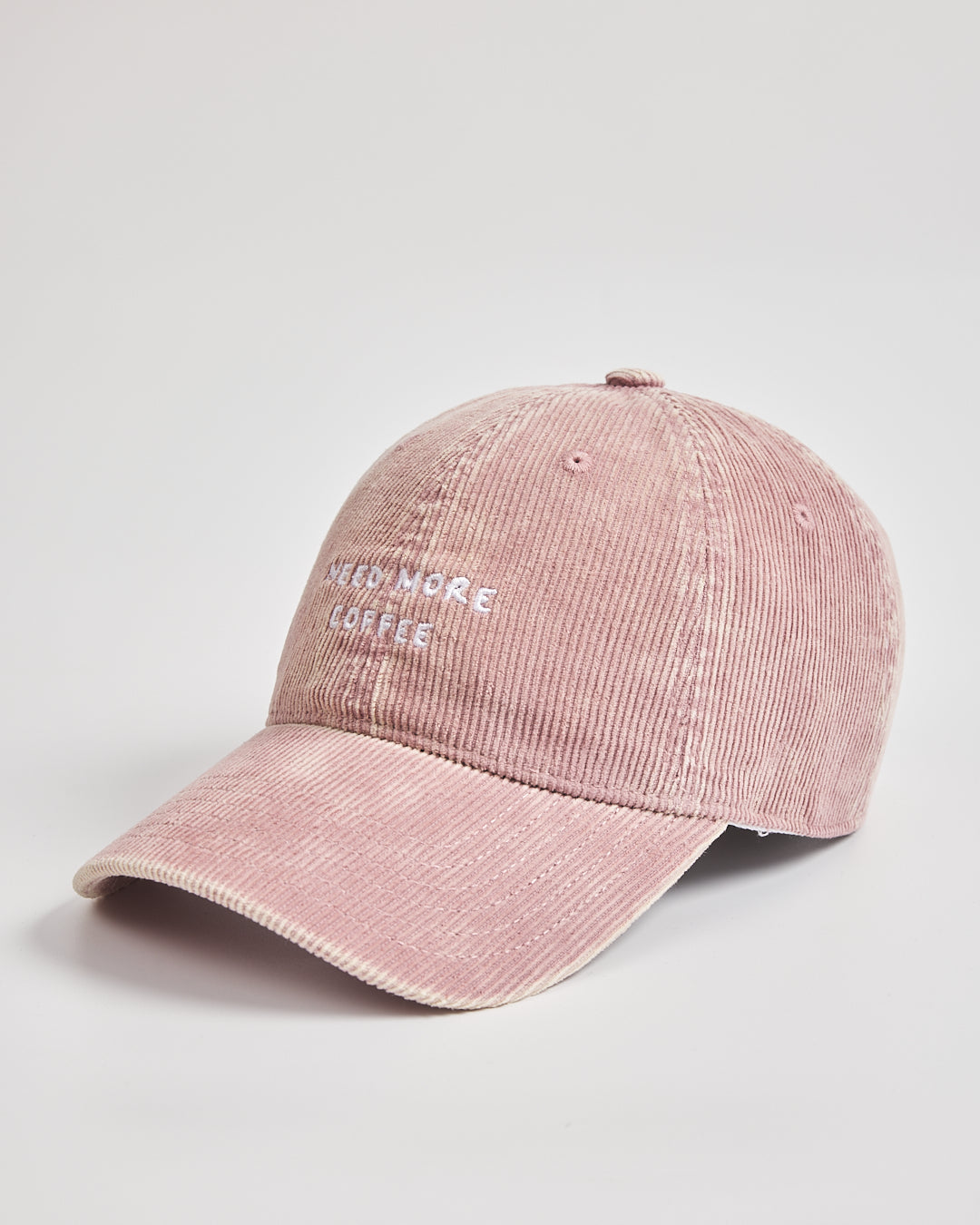 Pink corduroy cap with text on a light gray background