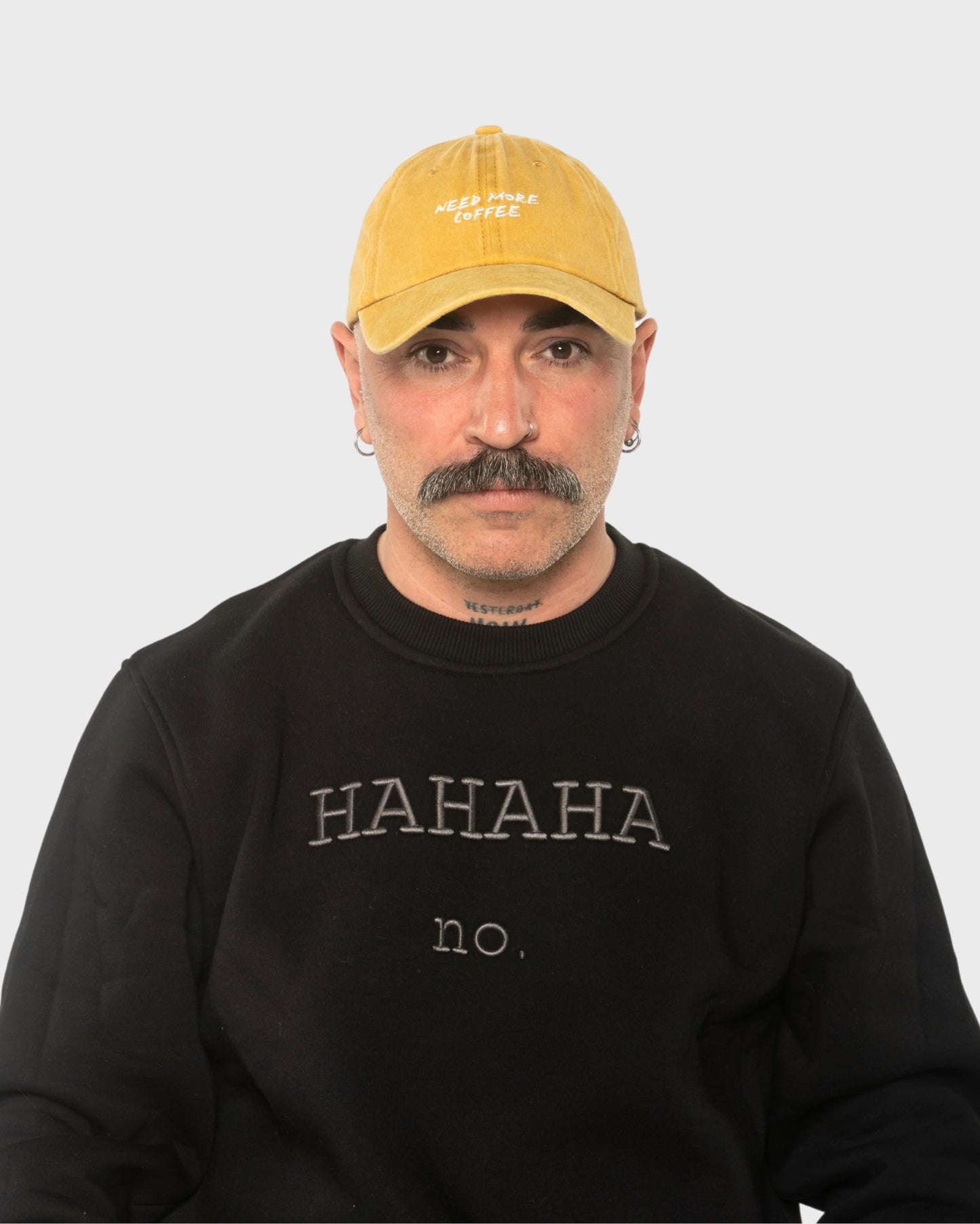 A man wearing the Need More Coffee Mustard Washed Cap