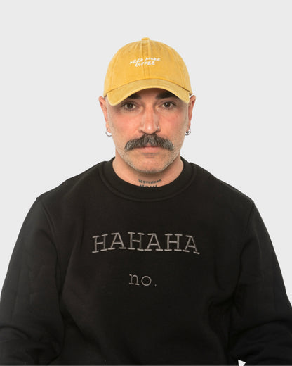 A man wearing the Need More Coffee Mustard Washed Cap