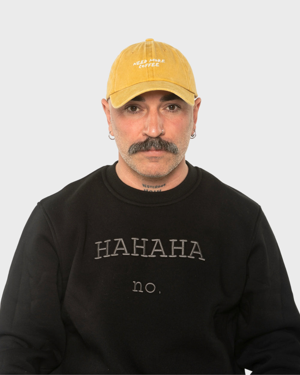 A man wearing the Need More Coffee Mustard Washed Cap
