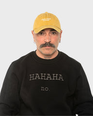 A man wearing the Need More Coffee Mustard Washed Cap