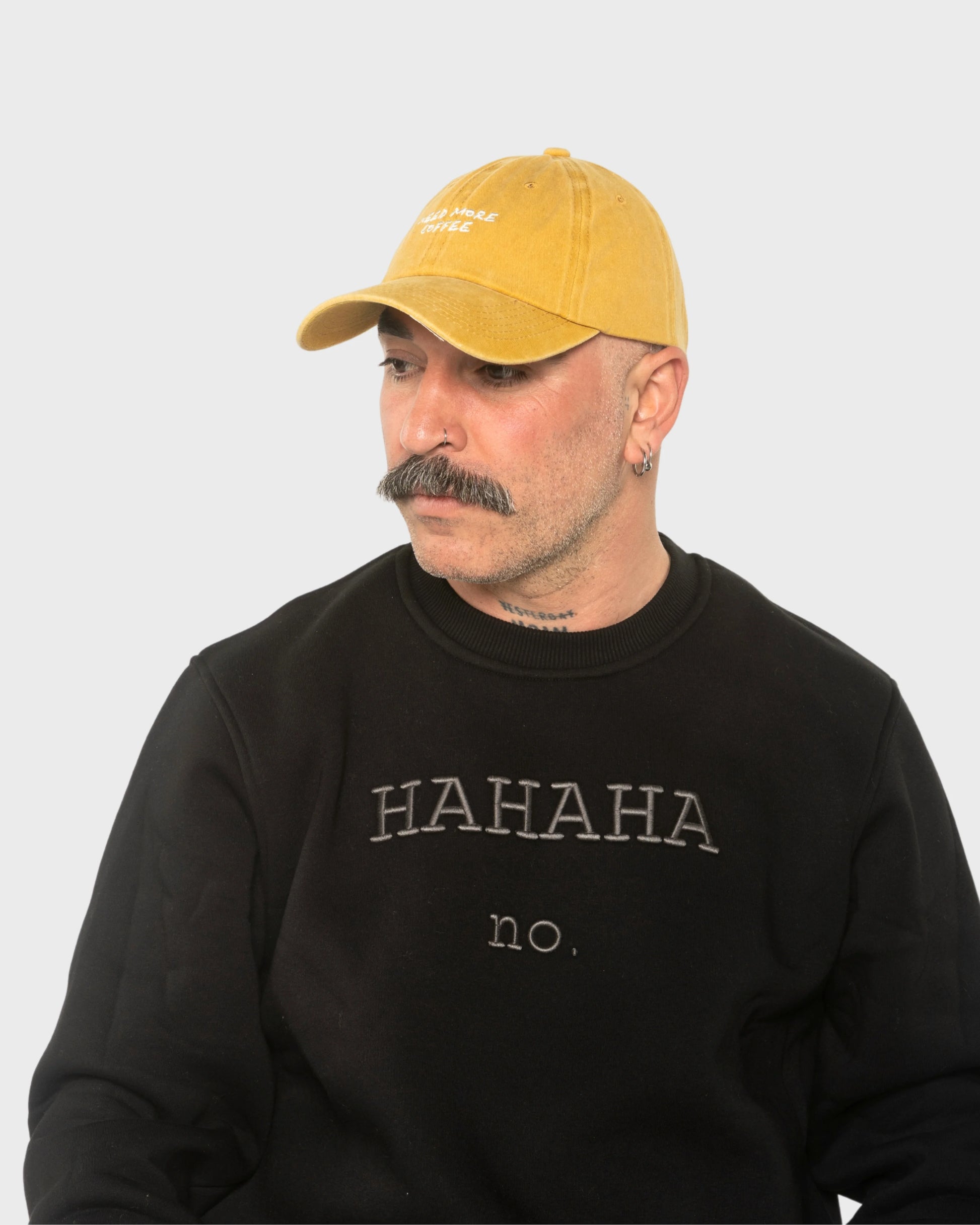 A man wearing the Need More Coffee Mustard Washed Cap