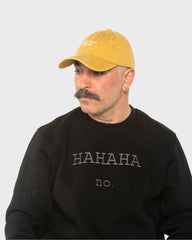 A man wearing the Need More Coffee Mustard Washed Cap