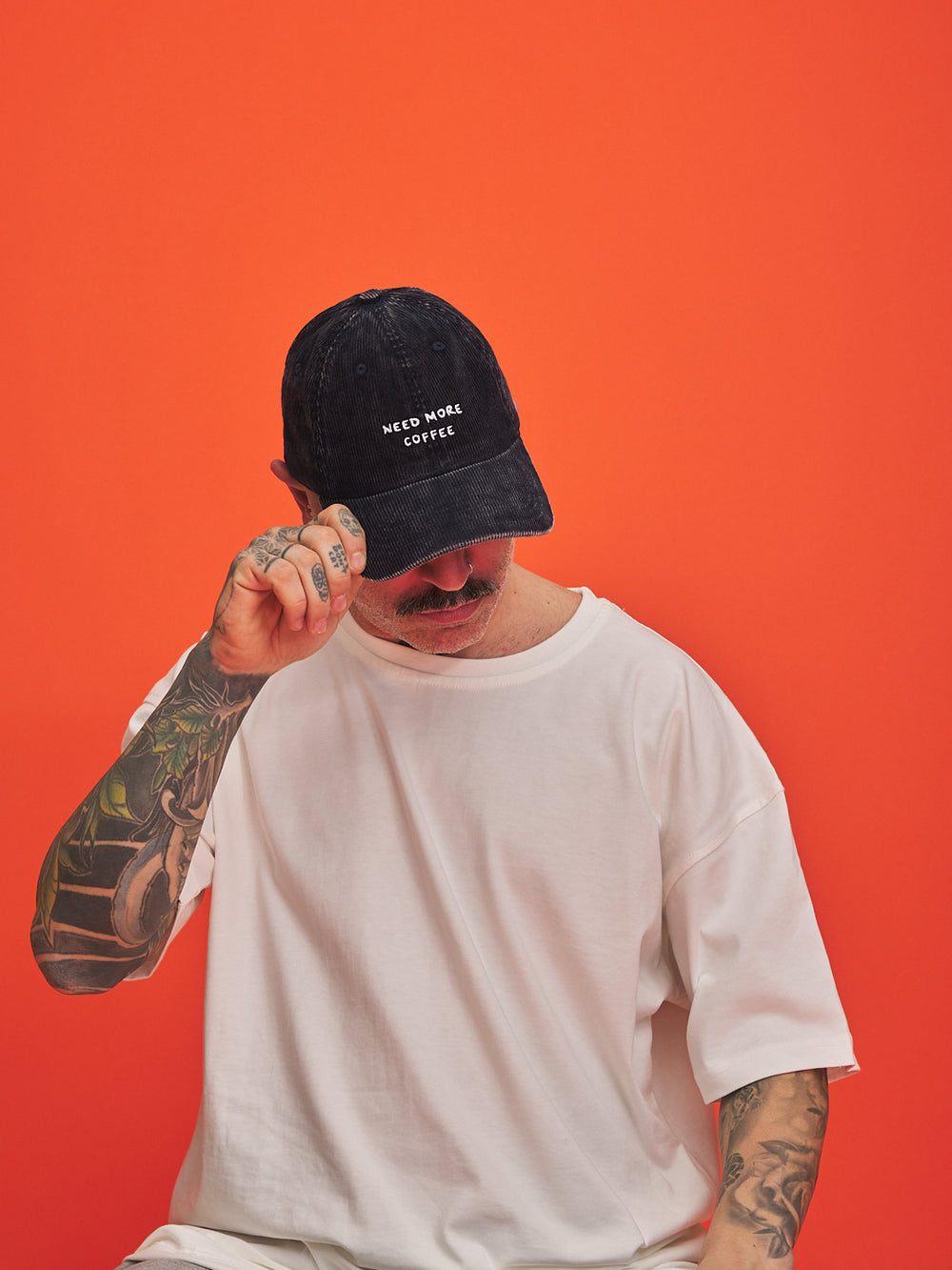Person wearing a navycap with text on an orange background