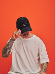 Person wearing a navycap with text on an orange background