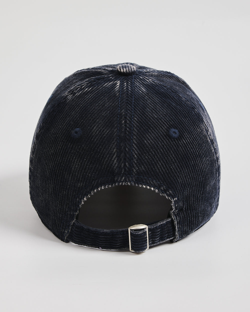 Navy corduroy cap on a light gray background