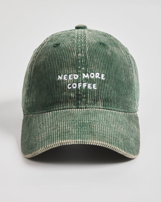 Green cap with 'Need More Coffee' text on a light gray background