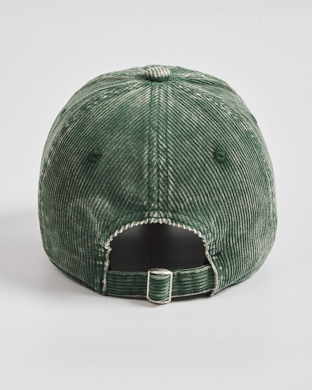Green corduroy cap on a light gray background