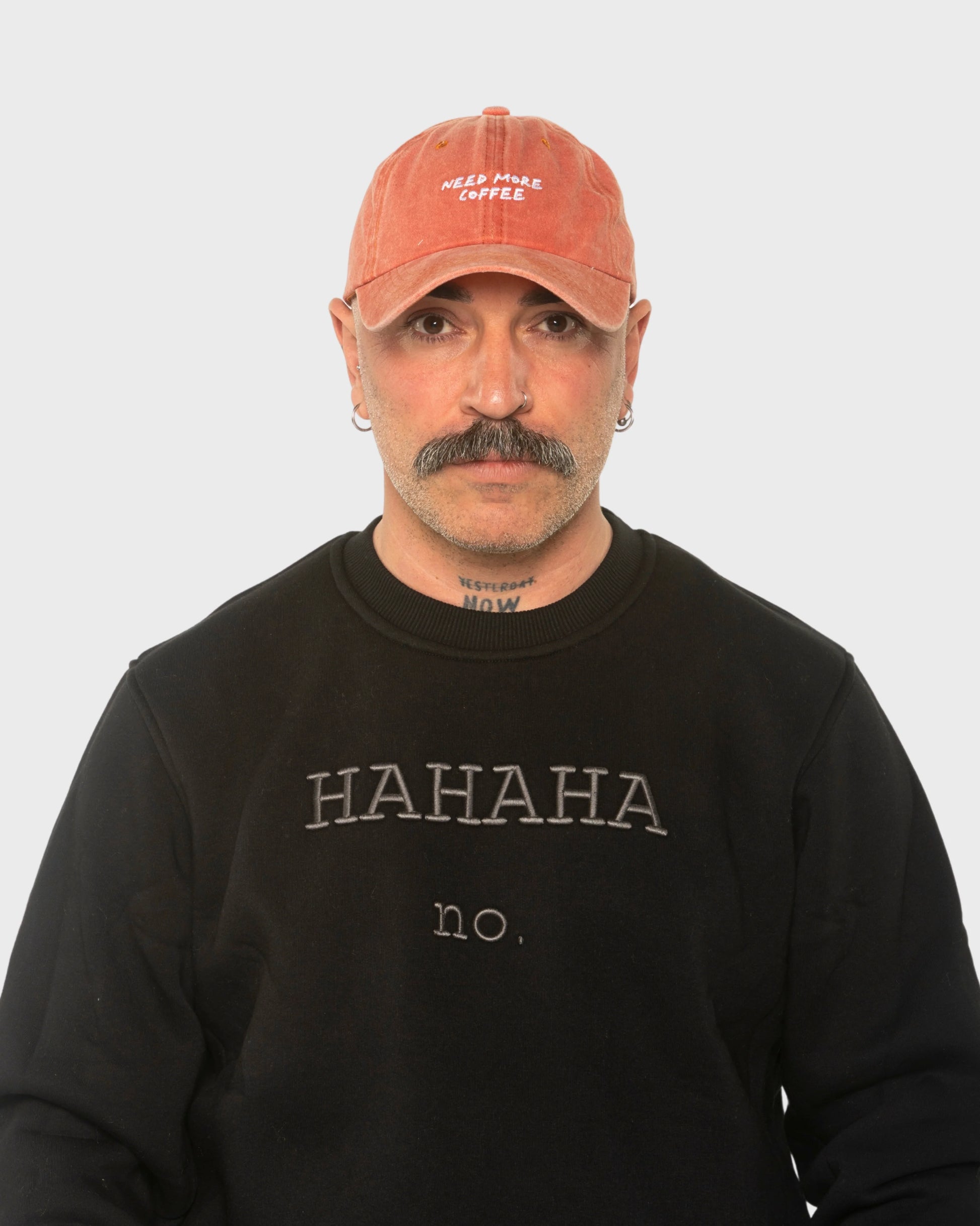 A man wearing the Need More Coffee Orange Washed Cap