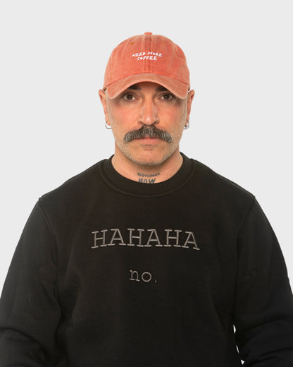 A man wearing the Need More Coffee Orange Washed Cap