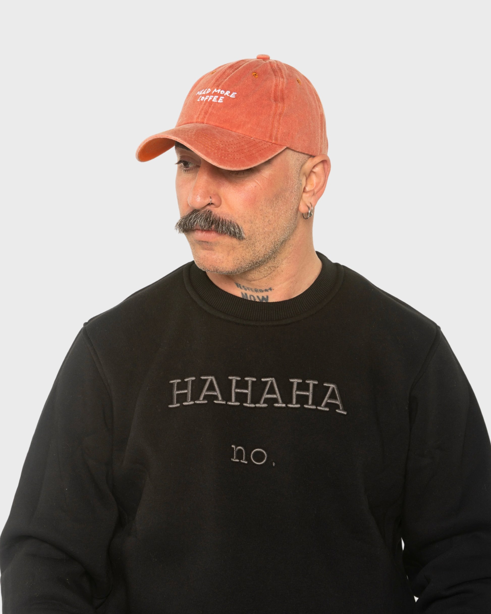 A man wearing the Need More Coffee Orange Washed Cap
