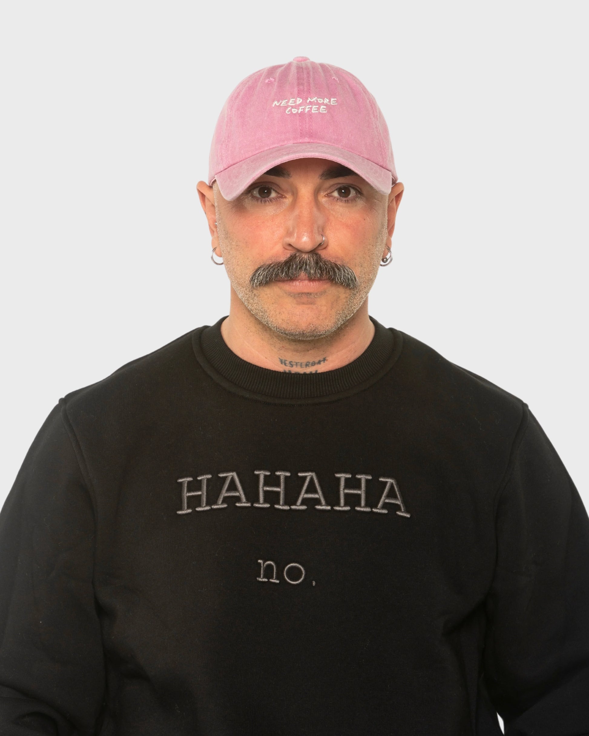 A man wearing the Need More Coffee Pink Washed Cap