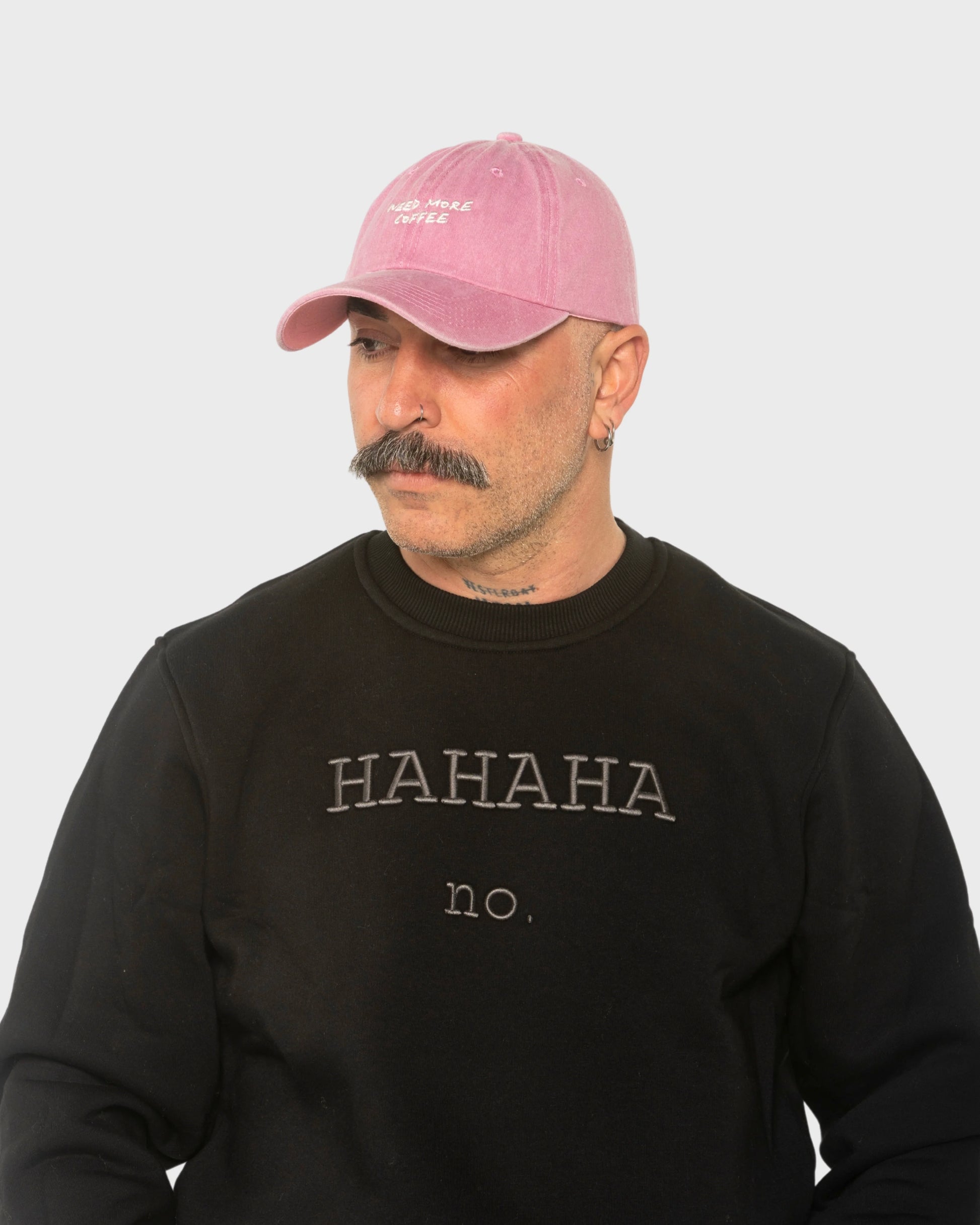 A man wearing the Need More Coffee Pink Washed Cap