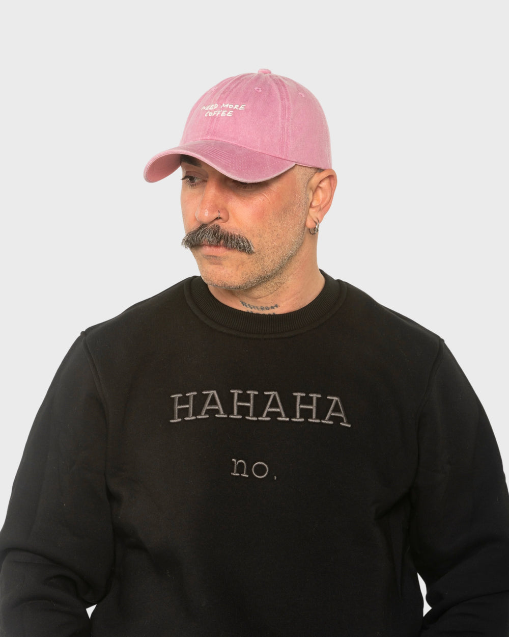 A man wearing the Need More Coffee Pink Washed Cap