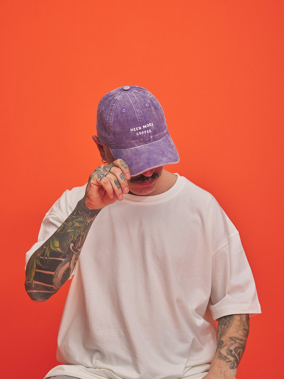 Person wearing a purple cap with text on an orange background