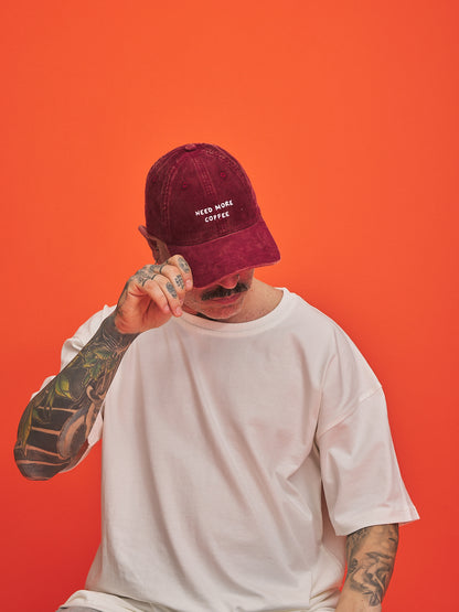 Person wearing a maroon cap with text on an orange background