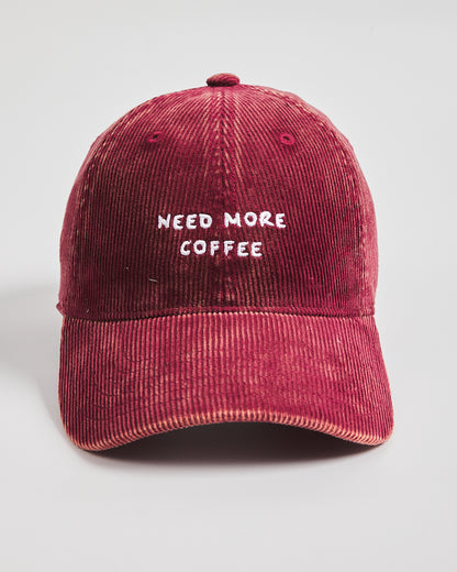 Red cap with 'NEED MORE COFFEE' text on a light gray background
