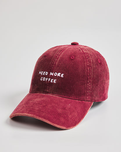 Red cap with 'NEED MORE COFFEE' text on a light gray background