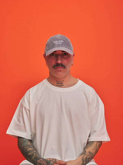 Man wearing a cap and white t-shirt against an orange background