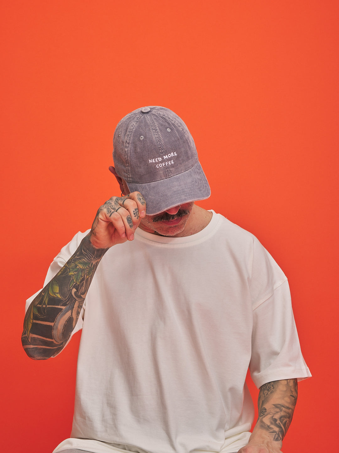 Person wearing a cap with text on an orange background