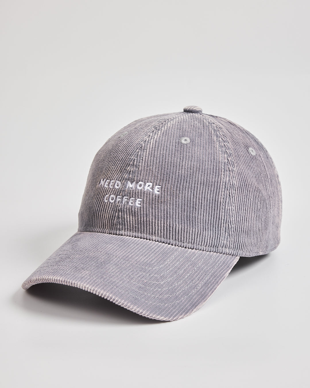 Gray cap with 'Need More Coffee' text on a light gray background
