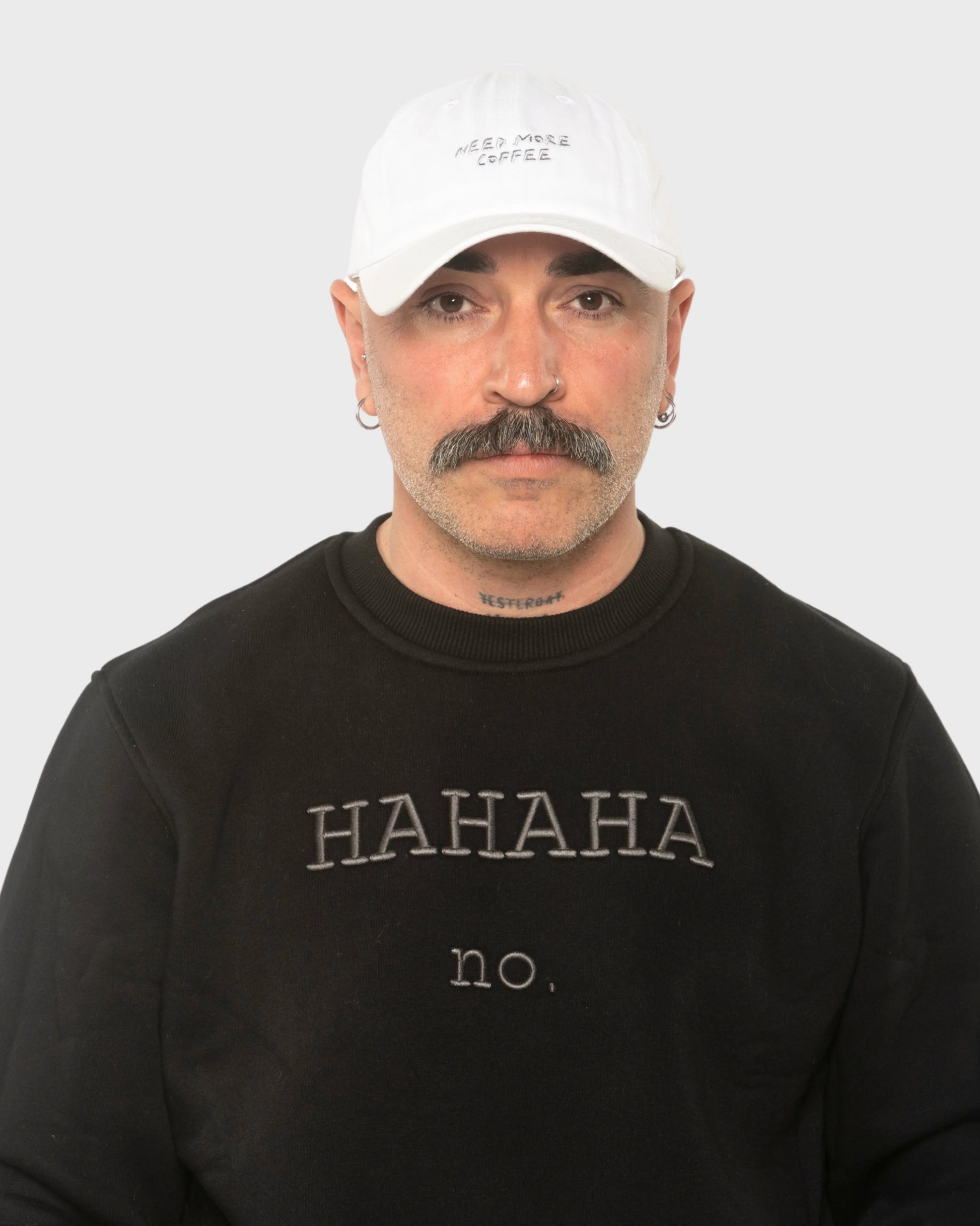 A man wearing the Need More Coffee White Washed Cap