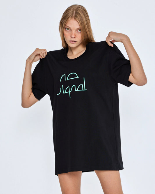 Person wearing a black t-shirt with green text on a white background