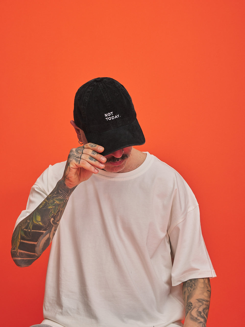 Person wearing a black cap with 'Not Today' text on an orange background