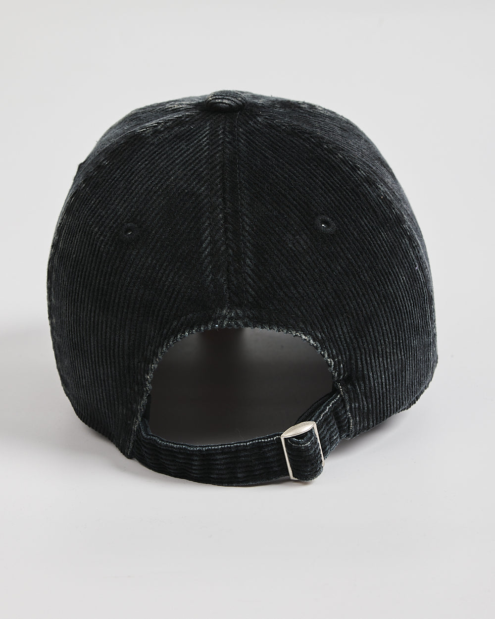 Black corduroy cap on a light gray background