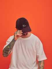 Person wearing a maroon cap with 'Not Today' text on an orange background