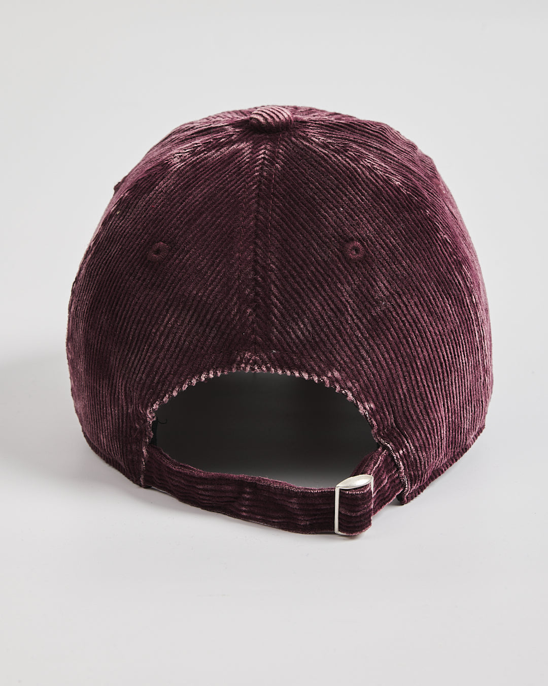 Maroon corduroy cap on a light gray background