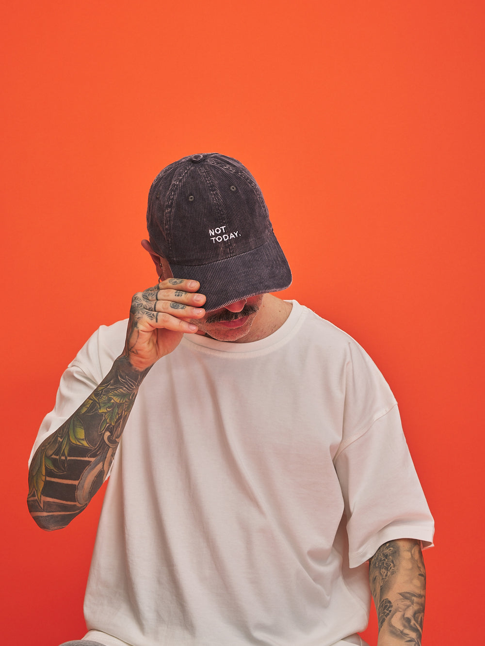 Person wearing a cap with 'Not Today' text on an orange background