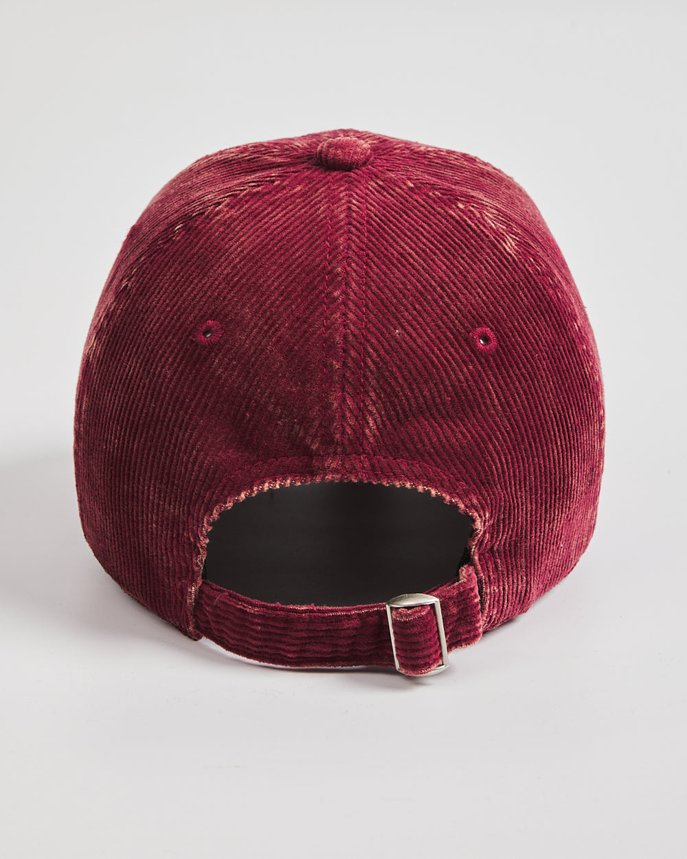 Maroon corduroy cap on a light gray background