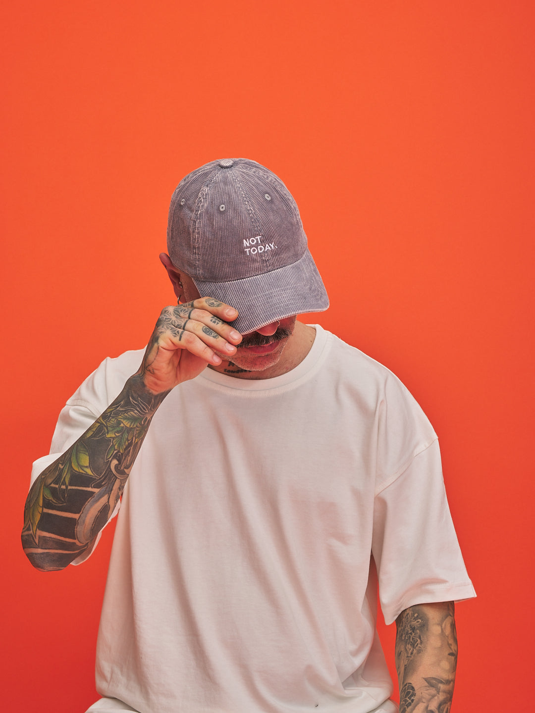 Person wearing a cap with 'Not Today' text on an orange background