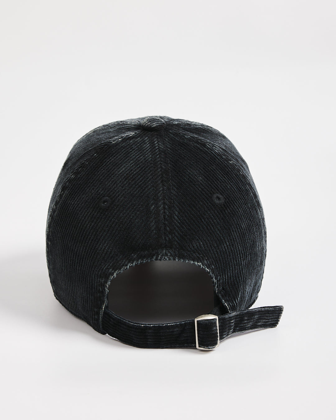 Black corduroy cap on a light gray background