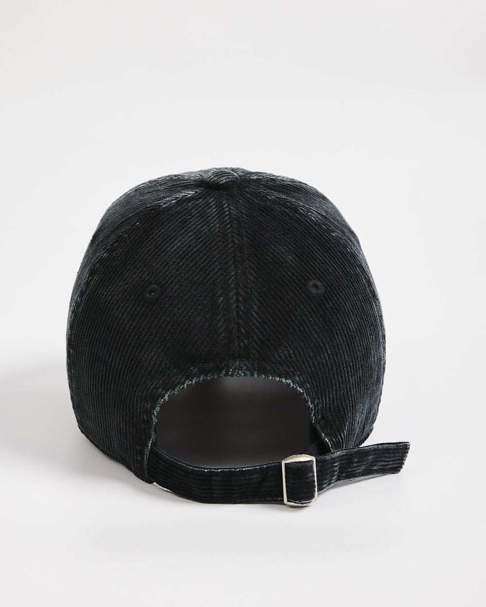 Black corduroy cap on a light gray background