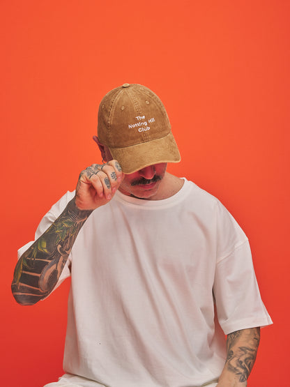 Person wearing a camel cap with text on an orange background