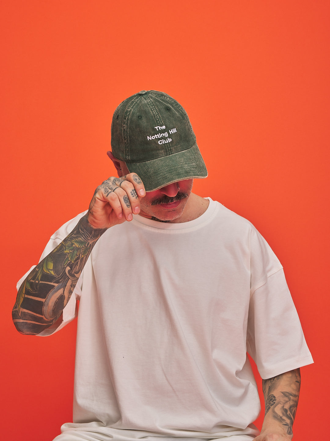 Person wearing a green cap with text on an orange background