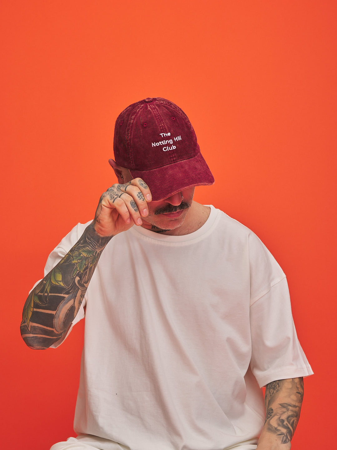 Person wearing a red cap with text on an orange background