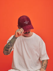 Person wearing a red cap with text on an orange background
