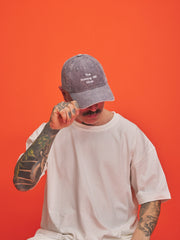 Person wearing a cap with text on an orange background