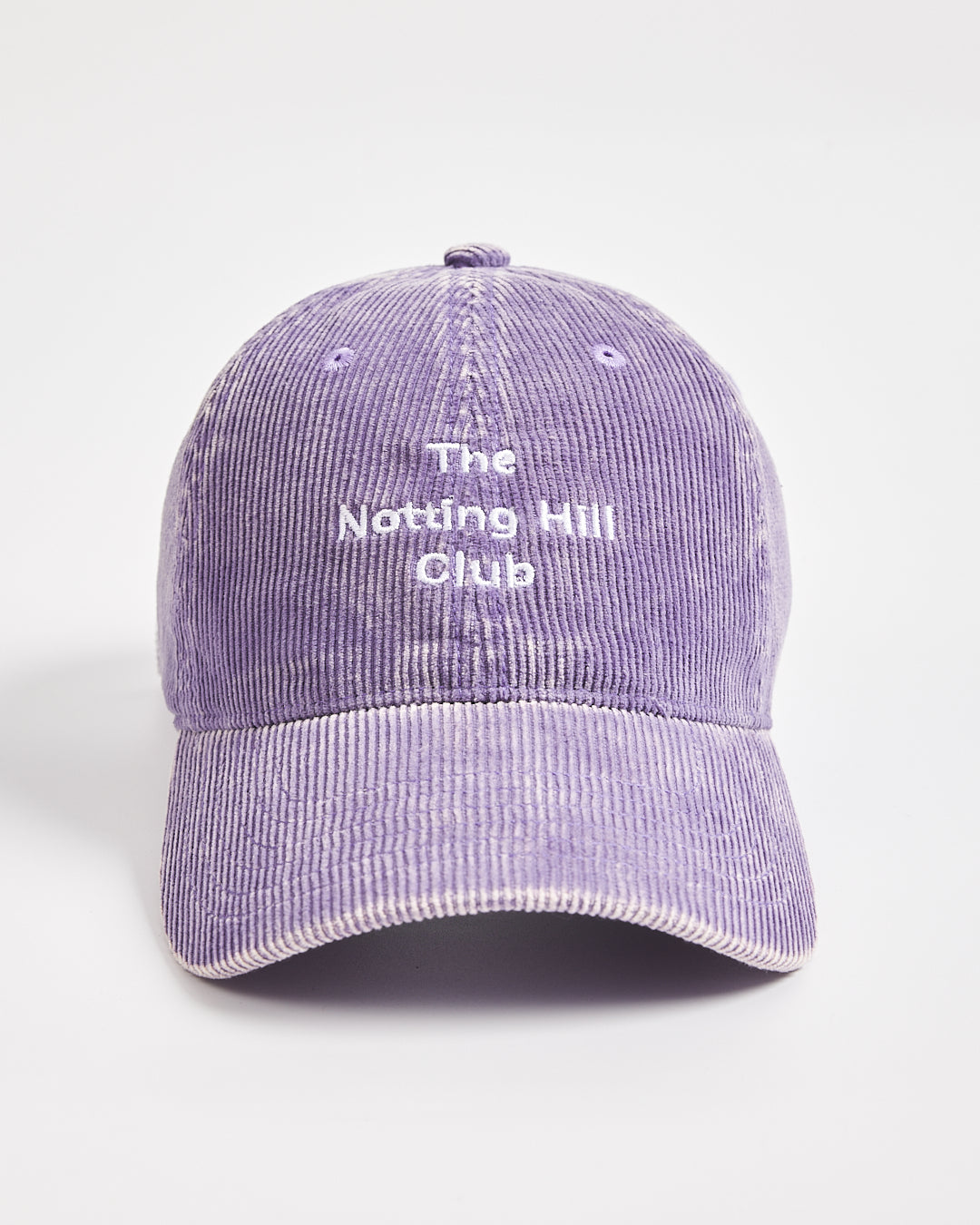 Purple corduroy cap with 'The Notting Hill Club' text on a light gray background