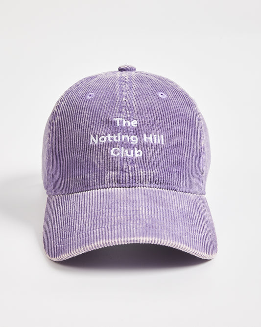 Purple corduroy cap with 'The Notting Hill Club' text on a light gray background