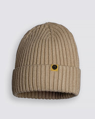 Oat Beige Classic Beanie with a gold logo tag on a light gray background
