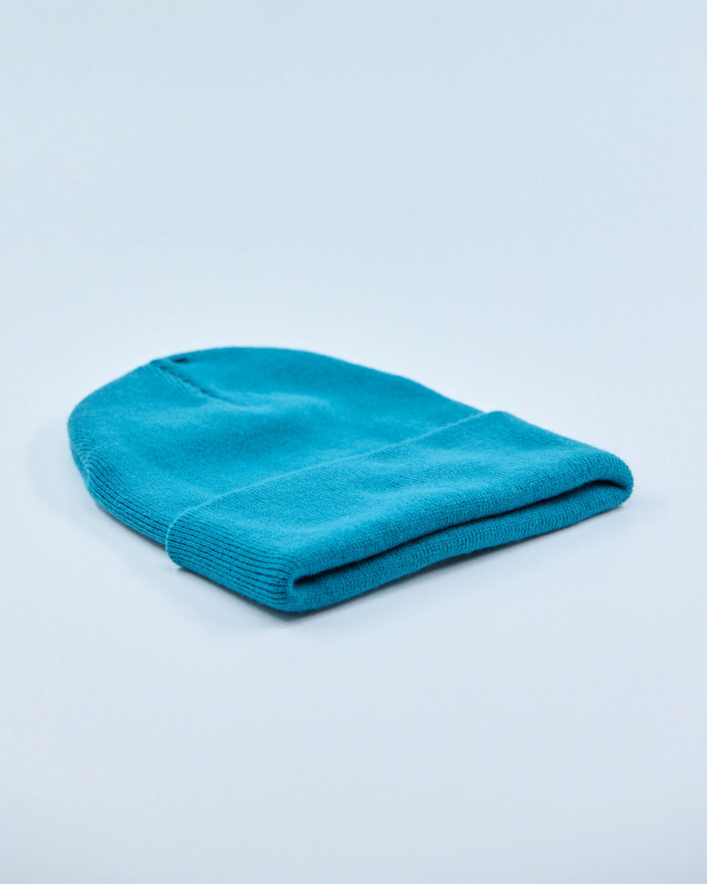Ocean teal beanie on a light blue background