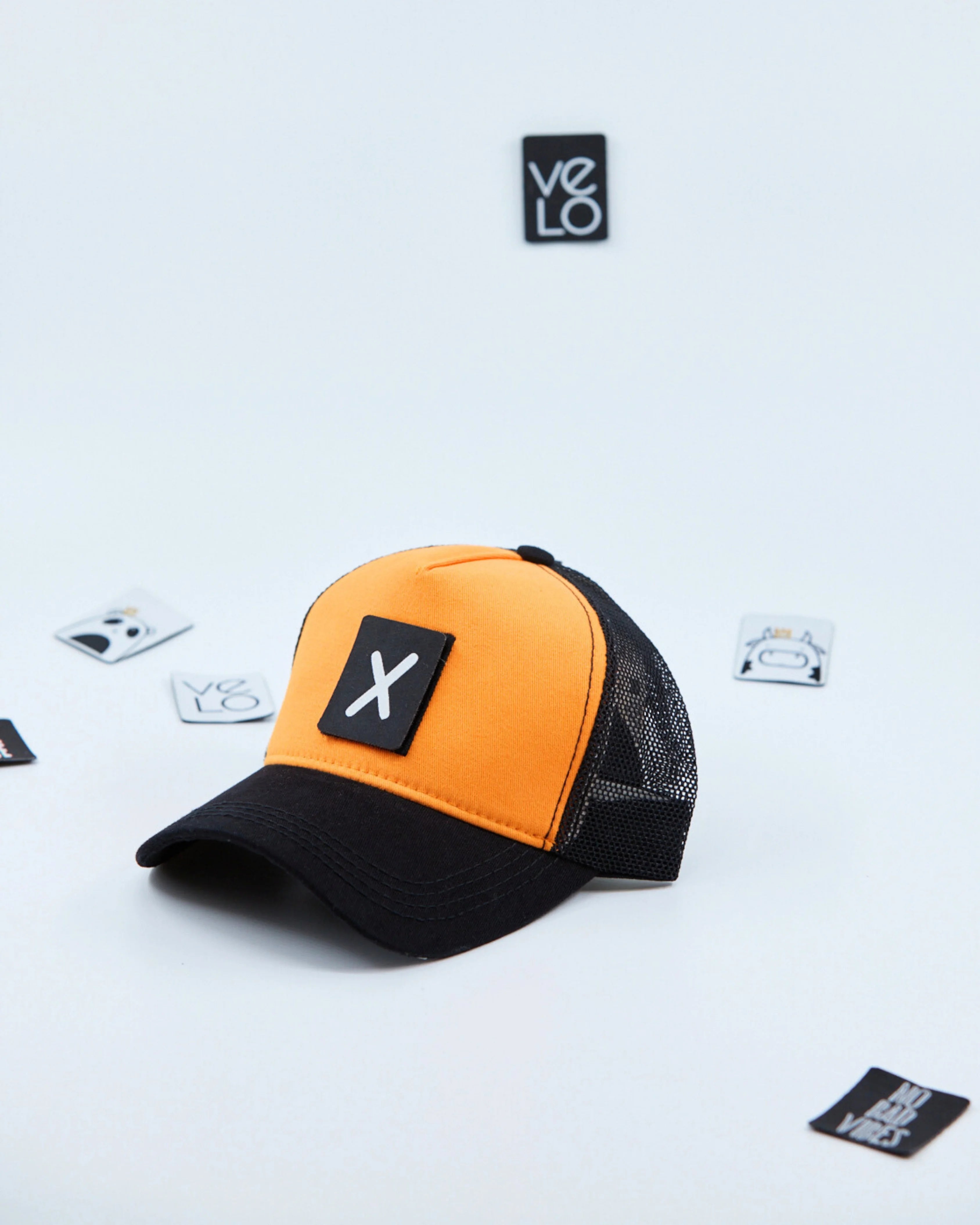 Side view of Orange and Black Customisable Trucker Cap with patches