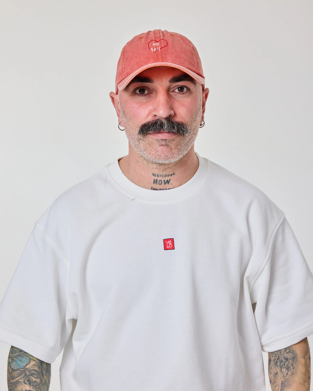 man wearing Orange Washed Cap with Love Myself embroidered in white